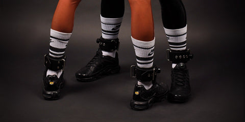 Models Showing How to Wear Elite Rubber Ankle Restraints with Metallic Buckles and Monogrammed Caps